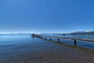 a pier stretches out into the water at Belleview Lakefront by Tahoe Getaways - Hot Tub, Pier, Buoy and Guest House in Homewood