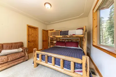 a bedroom with a bunk bed and a couch at Eagle Rock By Tahoe Getaways - 4BR West Shore w Hot Tub & Close to Hiking! in Homewood