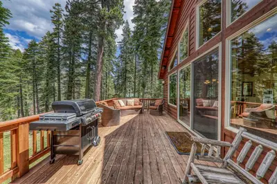 a screened in porch with a grill on a deck at Eagle Rock By Tahoe Getaways - 4BR West Shore w Hot Tub & Close to Hiking! in Homewood