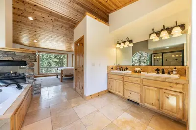 a large bathroom with two sinks and a fireplace at Eagle Rock By Tahoe Getaways - 4BR West Shore w Hot Tub & Close to Hiking! in Homewood