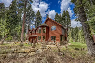 a log home in the woods with trees at Eagle Rock By Tahoe Getaways - 4BR West Shore w Hot Tub & Close to Hiking! in Homewood