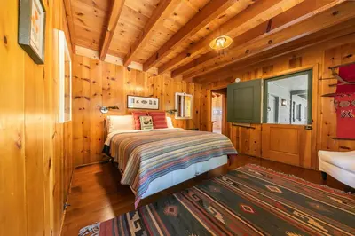 a bedroom with a bed in a wooden cabin at Sky Rocks - Private Beach, Buoy & Pier, HOA Swimming Pool & Tennis in Kings Beach