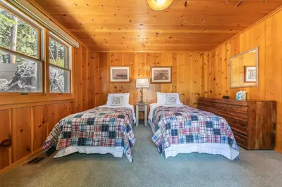 a bedroom with two beds in a wooden cabin at Sky Rocks - Private Beach, Buoy & Pier, HOA Swimming Pool & Tennis in Kings Beach