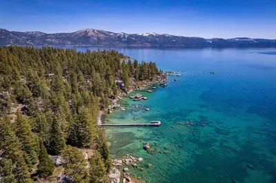 an aerial view of a lake with trees and blue water at Sky Rocks - Private Beach, Buoy & Pier, HOA Swimming Pool & Tennis in Kings Beach