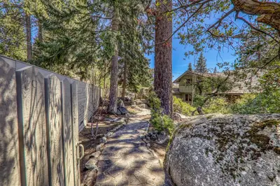 a fence and a path in front of a house at Sky Rocks - Private Beach, Buoy & Pier, HOA Swimming Pool & Tennis in Kings Beach
