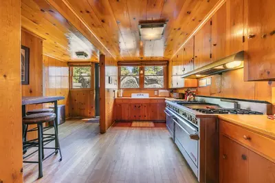 a kitchen with wooden cabinets and a stove top oven at Sky Rocks - Private Beach, Buoy & Pier, HOA Swimming Pool & Tennis in Kings Beach