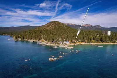 an island in the middle of a body of water at Spellbound Lakefront Lodge by Tahoe Getaways - 5 BR w Hot Tub, Buoy & Beach access in Kings Beach
