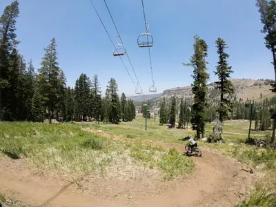 a person riding a bike on a dirt road under a ski lift at Kirkwood Retreat - 2 Bedroom Condo condo in Kirkwood