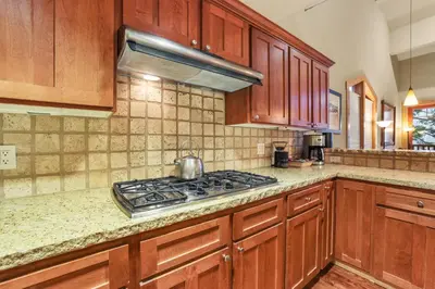 a kitchen with wooden cabinets and a stove top oven at Grandeur at Elevation – 3 Bedroom Loft condo in Kirkwood