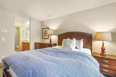 a bedroom with a large blue bed with two lamps at Grandeur at Elevation – 3 Bedroom Loft condo in Kirkwood