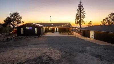 a house with lights on the side of it at 4000 SF, 20 Acre Gated Luxe Estate, Game Room, Pano View, Pool, Spa in Coarsegold