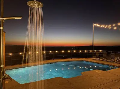 a swimming pool on top of a building at night at 4000 SF, 20 Acre Gated Luxe Estate, Game Room, Pano View, Pool, Spa in Coarsegold