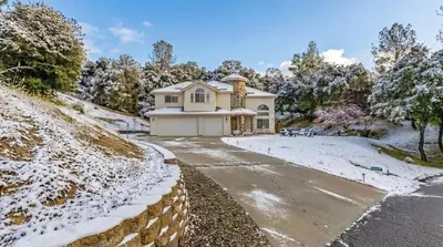a house on a snow covered hill with a driveway at Heaven Heights - HotTub, Pet Friendly, EV Outlet, Pool Table, Game Room, BBQ, FirePit, Library in Oakhurst