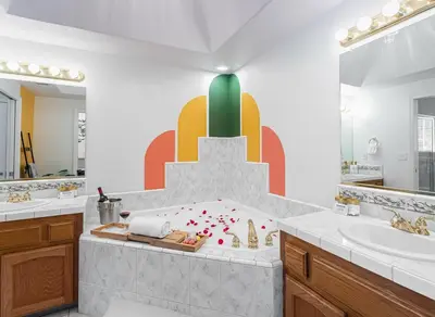 a bathroom with two sinks and a large painting on the wall at Heaven Heights - HotTub, Pet Friendly, EV Outlet, Pool Table, Game Room, BBQ, FirePit, Library in Oakhurst