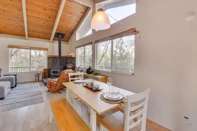 a dining room and living room with a table and chairs at Deck and Fire Pit Pine Mountain Lake Getaway! in Groveland