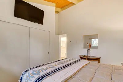 a bedroom with a bed with a tv on the wall at Deck and Fire Pit Pine Mountain Lake Getaway! in Groveland