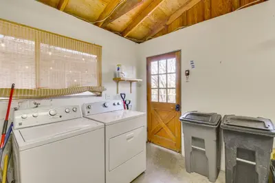 a kitchen with a washer and dryer and a door at Deck and Fire Pit Pine Mountain Lake Getaway! in Groveland