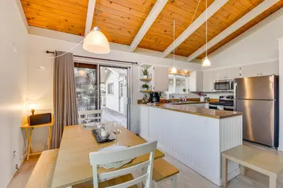 a kitchen with wooden ceilings and a dining room with a table at Deck and Fire Pit Pine Mountain Lake Getaway! in Groveland