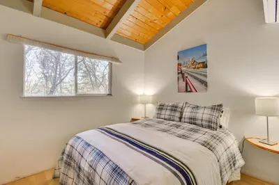 a bedroom with a bed and two lamps and a window at Deck and Fire Pit Pine Mountain Lake Getaway! in Groveland
