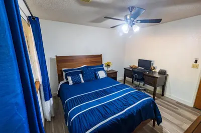 a bedroom with a bed and a desk with a ceiling fan at Sierra Vista Near Yosemite #Majestic Views# Tesla EV in Oakhurst