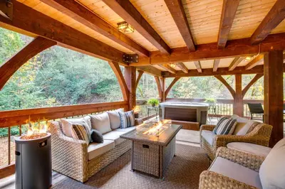 a screened in porch with couches and a fireplace at Bear Lodge Waterfront Cabin with Level 2 EV Charger in Sutter Creek