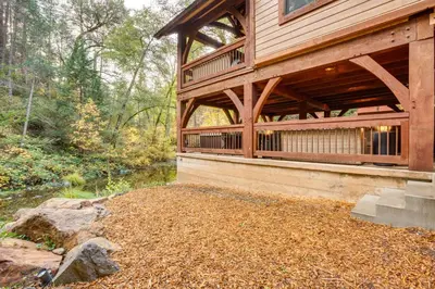 a wooden house in the middle of a forest at Bear Lodge Waterfront Cabin with Level 2 EV Charger in Sutter Creek