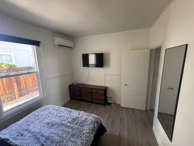 a bedroom with a bed and a television on the wall at Midtown Hideaway 1 BR Nest in Reno