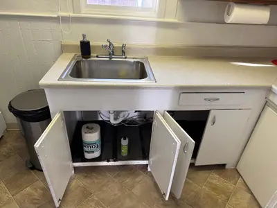 a kitchen sink with the door open under it at Midtown Hideaway 1 BR Nest in Reno