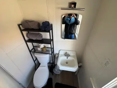 a person taking a picture of a bathroom with a toilet and sink at Midtown Hideaway 1 BR Nest in Reno