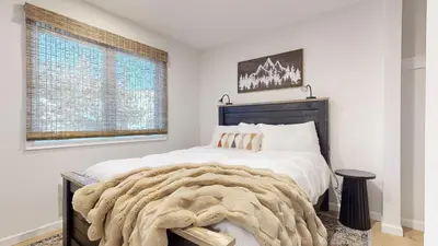 a bedroom with a large bed and a large window at Lakeview Villas #06 condo in Mammoth Lakes