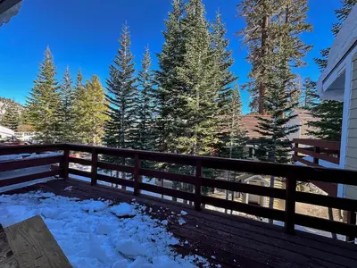 a balcony with snow on a fence and trees at Lakeview Villas #06 condo in Mammoth Lakes
