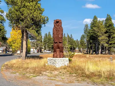 a wooden bear statue in the middle of a road at Awesome Home Above the Lake - Dogs Welcome VH315 in Bear Valley