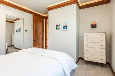 a bedroom with a white bed and a dresser at Obsidian 210 in Mammoth Lakes