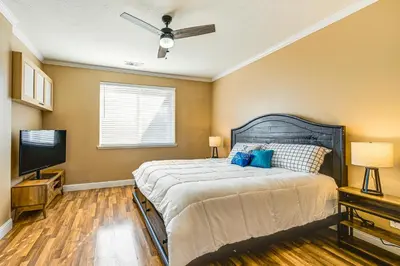 a bedroom with a large bed with a ceiling fan at 26 Mi to Fresno Pet-Friendly Home in Reedley! in Reedley