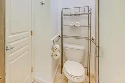 a bathroom with a toilet with a metal rack at 26 Mi to Fresno Pet-Friendly Home in Reedley! in Reedley