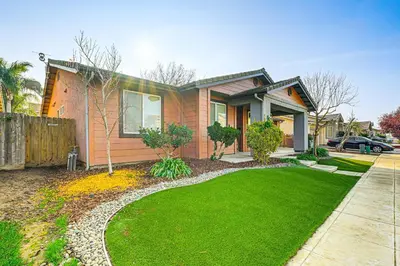 a house with a green lawn in front of it at 26 Mi to Fresno Pet-Friendly Home in Reedley! in Reedley