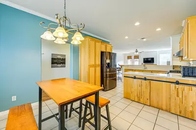 a kitchen with wooden cabinets and a wooden table at 26 Mi to Fresno Pet-Friendly Home in Reedley! in Reedley