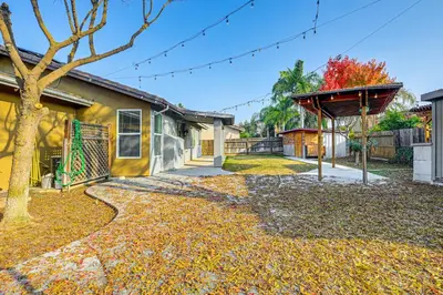 a house with a tree in the yard at 26 Mi to Fresno Pet-Friendly Home in Reedley! in Reedley