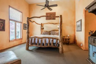 a bedroom with a wooden bed and a ceiling fan at XXL Snowcreek #747 - 5 Bedroom 4 Bathroom Sleeps 12 Pet Friendly, Amazing Mountain Views in Mammoth Lakes