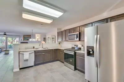 a kitchen with wooden cabinets and stainless steel appliances at 4 Mi to San Joaquin River Peaceful Patterson Home in Patterson