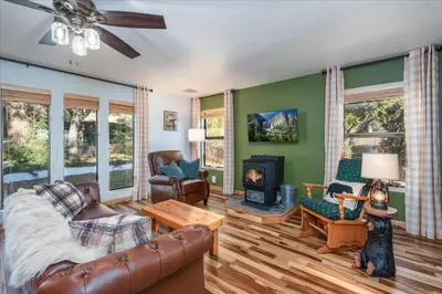 a living room with leather furniture and a fireplace at Sequoia's Dream with Mountain View, Spa, Heated Floor, Bar, Cinema! in Oakhurst