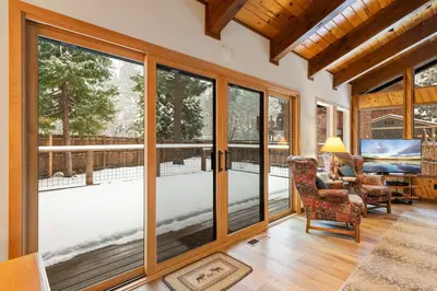 a living room with sliding glass doors and a view of a deck at Cabin for 8 HotTub Close to Ski Town Private Beach in Tahoe City
