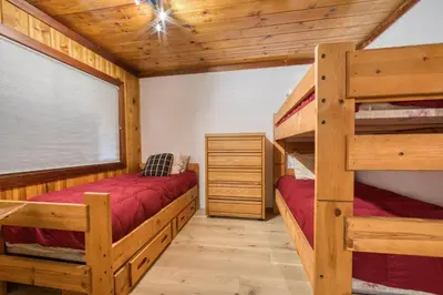 a bedroom with two bunk beds in a log cabin at Wanderlust Retreat by Tahoe Getaways - 4BR Pet-Friendly w Fenced Yard, Walking Distance to Lake! in Tahoe City