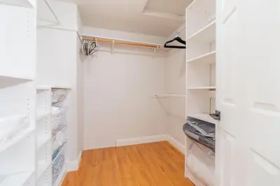 a walk in closet with white cabinets and wood floors at Modern 3-Bedroom Escape in Northwest Reno in Reno