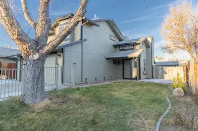 a white house with a tree in the yard at Modern 3-Bedroom Escape in Northwest Reno in Reno