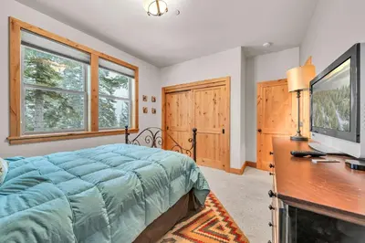 a bedroom with a bed and a desk with a television at Spacious Tahoma Retreat with Hot Tub and Game Room in Tahoma