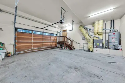 an empty garage with a large door and a staircase at Spacious Tahoma Retreat with Hot Tub and Game Room in Tahoma