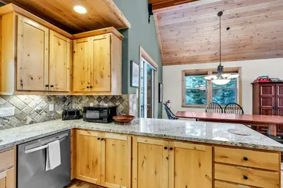a kitchen with wooden cabinets and a counter top at Spacious Tahoma Retreat with Hot Tub and Game Room in Tahoma