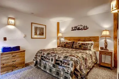 a bedroom with a bed and a dresser and lamp at Alpine View in Yosemite West