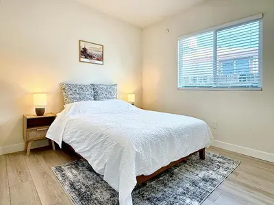 a bedroom with a white bed and a window at 5 Min Walk to UCD Med Ctr - Stylish New Build Home in Sacramento